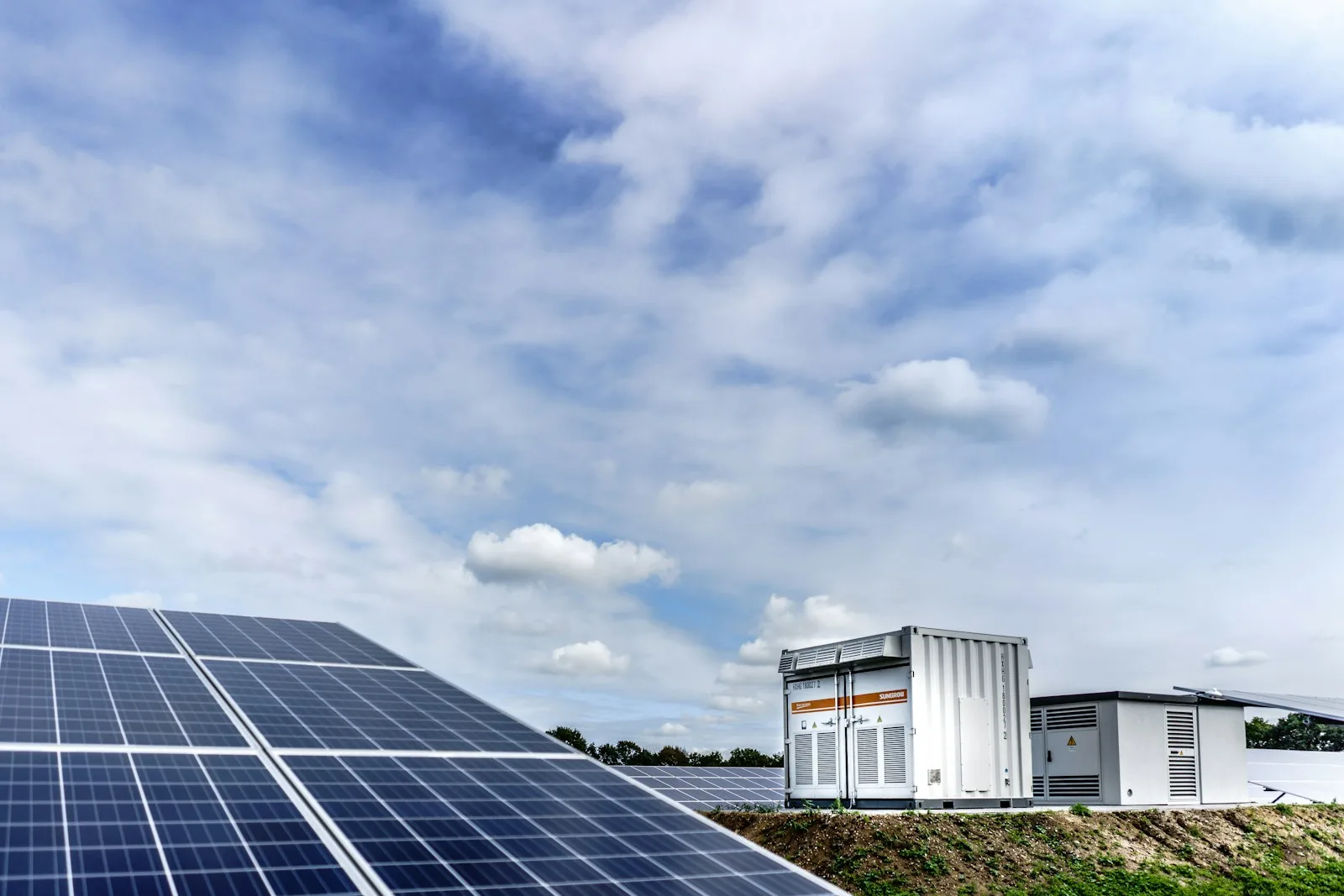 Co-Located Batteriespeicher-Projekt — großer BESS-Container neben PV-Freiflächenanlage am selben Netzverknüpfungspunkt